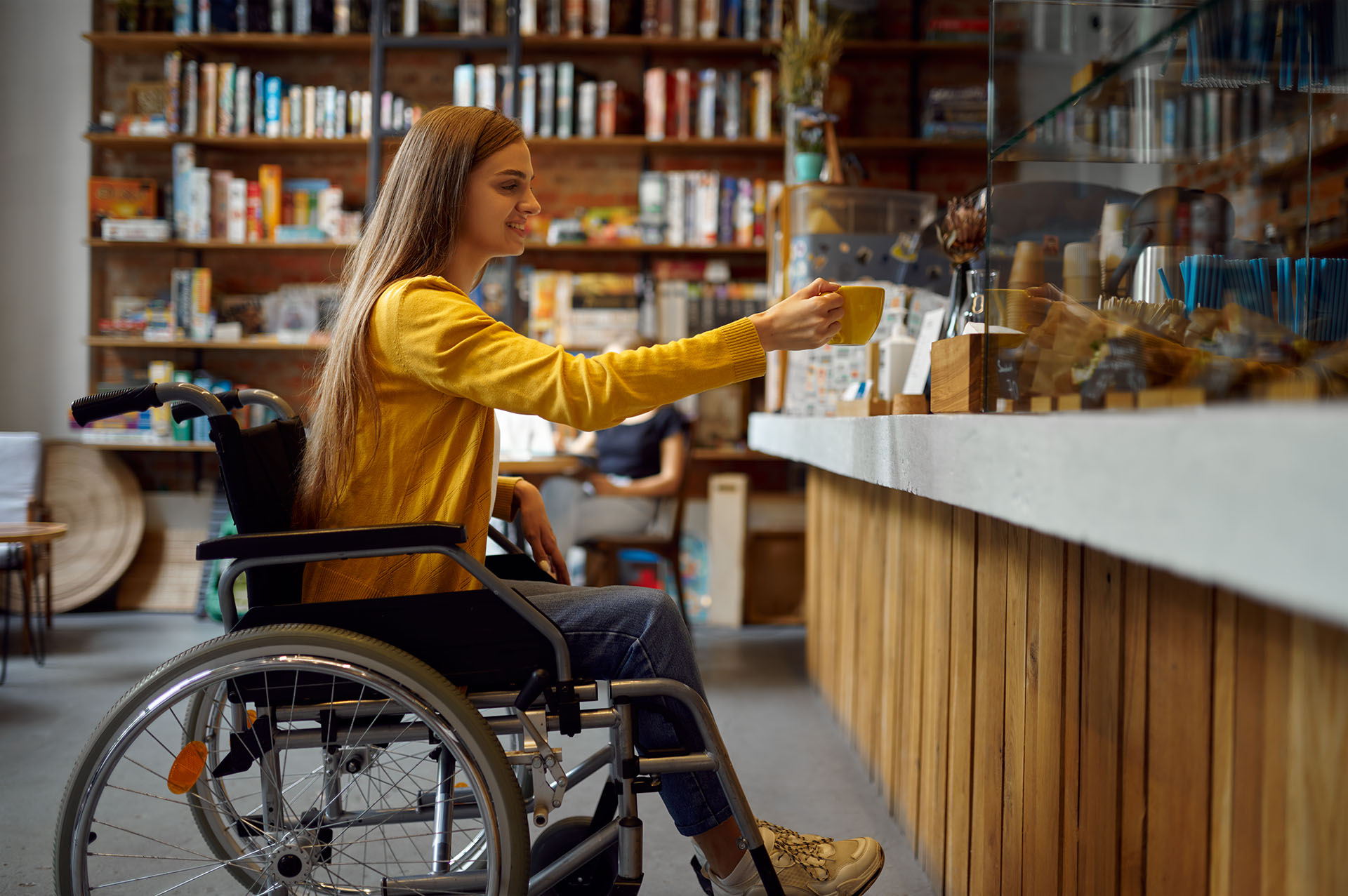 Disabled female student in wheelchair in cafe with a student accommodation in Exeter